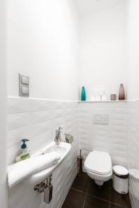 um banheiro branco com vaso sanitário e pia em Luxury Apartment with Spacious Livingroom at Opera House em Budapeste mais 15 fotografias