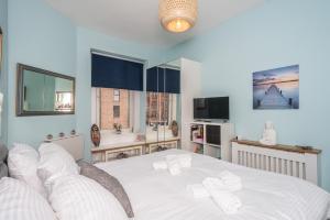 1 dormitorio con 1 cama blanca grande con almohadas blancas en Pass the Keys Trendy Historic flat sleeps 4 to 6 near Leith Shore, en Edimburgo