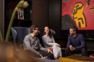 un grupo de tres personas sentadas en una habitación en art'otel Zagreb, Powered by Radisson Hotels, en Zagreb
