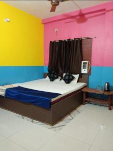 a bed in a room with a colorful wall at Parinay Vatika Inn in Deoghar