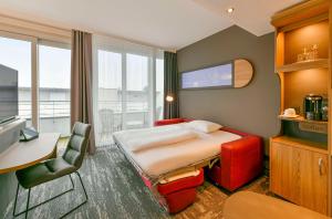 Habitación de hotel con cama, mesa y escritorio. en Best Western Plus Hotel Papenburg en Papenburg