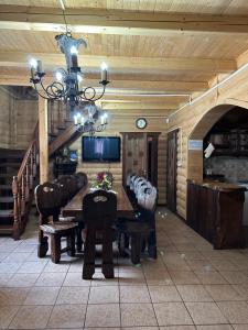 una sala da pranzo con tavolo, sedie e lampadario pendente di Palaga Bukovel a Bukovel
