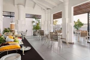 a dining room with a table with food on it at GRAN HOTEL EUROPA TRADEMARK COLLECTION by WYNDHAM in Santo Domingo