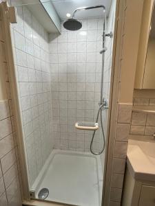 een douche met een glazen deur in de badkamer bij Vakantiechalet voor 4 plus 2 met sauna in Lanaken