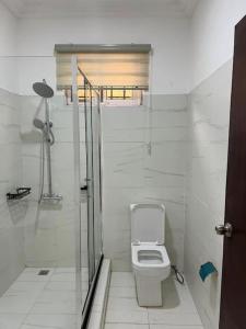 y baño blanco con aseo y ducha. en Wyndham Villa, en Ogbojo