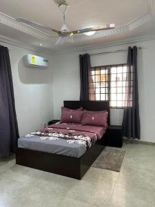 Schlafzimmer mit einem Bett und einem Deckenventilator in der Unterkunft Wyndham Villa in Ogbojo