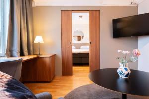 sala de estar con mesa y dormitorio en Best Western Plus Park City Solna, en Solna