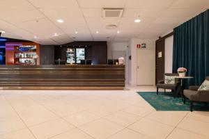 a lobby with a waiting area with chairs and a bar at Best Western Plus Park City Solna in Solna