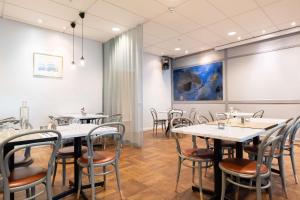 a restaurant with tables and chairs in a room at Best Western Plus Park City Solna in Solna