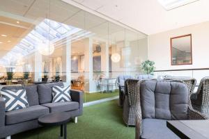 a waiting room with couches and a table and chairs at Best Western Plus Park City Solna in Solna