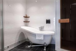 a white bathroom with a tub and a sink at Best Western Plus Park City Solna in Solna