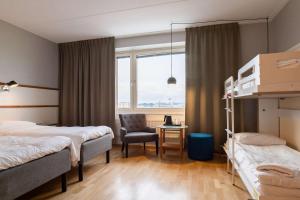 a hotel room with two beds and a chair at Best Western Plus Park City Solna in Solna