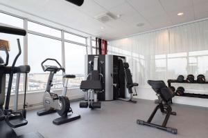 a gym with cardio equipment in a room with windows at Best Western Plus Park City Solna in Solna