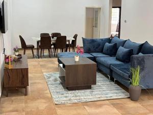 a living room with a blue couch and a table at Wyndham Villa in Ogbojo