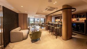 a room with a bar with chairs and a table at HCM - Hotel Corais de Manaira in João Pessoa