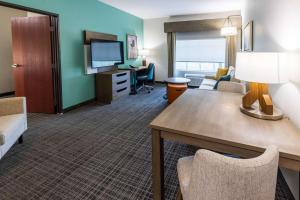 uma sala de estar com um sofá e uma mesa num quarto de hotel em Comfort Inn & Suites New Iberia - Avery Island em New Iberia