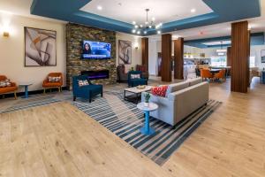 a lobby with a couch and chairs and a fireplace at Comfort Inn & Suites New Iberia - Avery Island in New Iberia