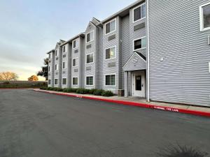 un parking vide à côté d'un grand bâtiment dans l'établissement SureStay by Best Western Sacramento South Natomas, à Sacramento