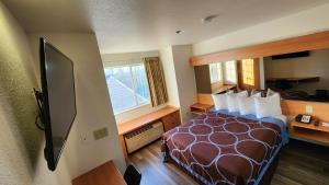 a hotel room with a bed and a television at SureStay by Best Western Sacramento South Natomas in Sacramento