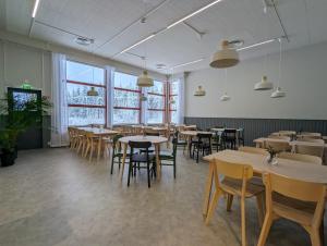 a dining room with tables and chairs and windows at Arctic Nest in Kotila