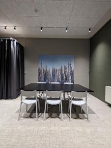 a black table and chairs in a room with a picture of trees at Arctic Nest in Kotila