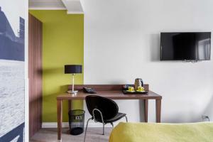 a room with a desk with a chair and a television at Best Western Plus Park Globetrotter Copenhagen Airport in Copenhagen