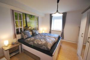 Schlafzimmer mit einem Bett mit Wandgemälde in der Unterkunft Ferienhaus Eichenhof 35648 in Uplengen