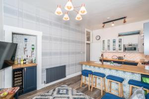 una cocina con una barra con sillas azules en Pass the Keys Trendy Historic flat sleeps 4 to 6 near Leith Shore, en Edimburgo