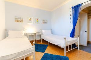 2 camas en una habitación con alfombras azules en 3 The Old School House, en St. Agnes