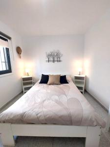 プラヤ・オンダにあるAgua Marinaの白いベッドルーム(ランプ2つ付きの大型ベッド1台付)