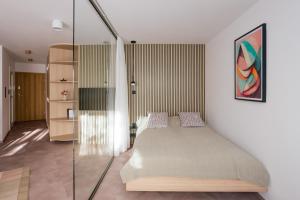 a bedroom with a bed and a glass wall at Home From Home - Kraków, Podgórze in Kraków