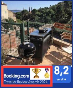 een grill op een patio met uitzicht op een tuin bij CAVALAIRE vue MER au loin MAISONNETTE TOUT ÉQUIPÉE POUR 4 PERSONNES AVEC PISCINE CLIM WIFI VÉLOS TV BARBECUES in Cavalaire-sur-Mer