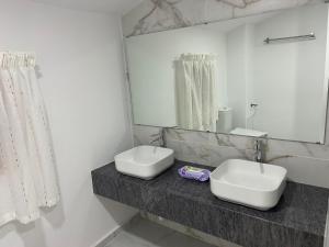 a bathroom with two sinks and a mirror at Guest house Asta in Saparewo