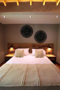 a bedroom with a large bed with white sheets and pillows at Heura Petit Hotel in Ciudad Lujan de Cuyo