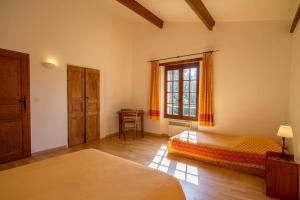 a bedroom with a bed and a window at L'Oubradou Mas de charme shared pool in Provence nature and calm in Flayosc