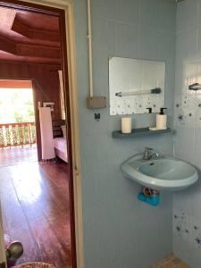 een badkamer met een wastafel en een spiegel aan de muur bij Bungalow in the jungle in Salad Beach