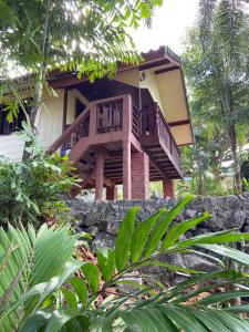 une maison avec une terrasse au-dessus d'un mur en pierre dans l'établissement Bungalow in the jungle, à Salad Beach