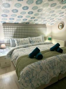 a bedroom with a large bed with blue pillows at Summerhill Guest House in Betws-y-coed