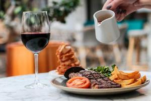 einen Teller mit Essen und ein Glas Rotwein in der Unterkunft DoubleTree by Hilton York in York