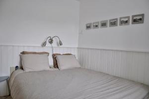 - un lit avec des draps et des oreillers blancs dans l'établissement De Blenck 7, à Callantsoog