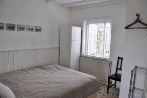- une chambre avec un lit, une fenêtre et une chaise dans l'établissement De Blenck 7, à Callantsoog