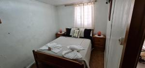 a small bedroom with a bed with towels on it at Casa das bonecas in Castro Daire