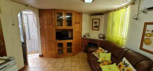 a living room with a couch and a entertainment center at Casa das bonecas in Castro Daire