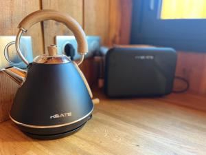a tea kettle sitting on top of a wooden table at La cabane du Broustic in Andernos-les-Bains