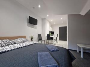 a bedroom with a large bed and a table with chairs at Willa Lawenda Apartament 6 in Rytro