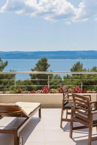 einen Balkon mit einem Tisch und Stühlen sowie Blick auf das Wasser in der Unterkunft Villa Jolara With Pool - Deluxe Suite 6 in Mimice