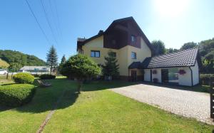 a house with a large yard with a driveway at Willa Lawenda Apartament 6 in Rytro