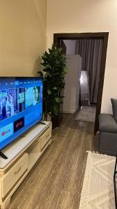 uma sala de estar com uma televisão de ecrã plano num centro de entretenimento em شقة ب الحمراء بدخول ذاتي em Riyadh