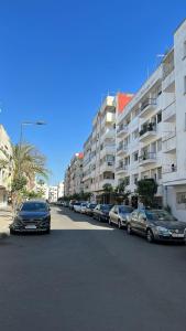 una fila de autos estacionados frente a un edificio en Agréable appartement, en Rabat