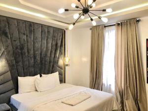 um quarto com uma cama grande e uma cabeceira preta em Three Bedroom Homely Apartment em Lekki